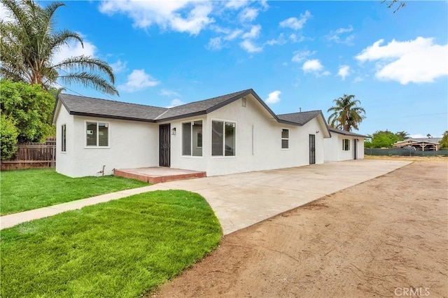 7307 Diamond St, Riverside, CA 92504 - view of front of property with fence, a front yard, stucco siding, and driveway