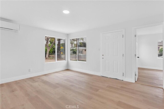 7307 Diamond St, Riverside, CA 92504 - unfurnished room with recessed lighting, an AC wall unit, baseboards, and light wood-style floors