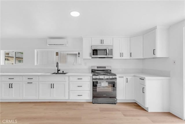 7307 Diamond St, Riverside, CA 92504 - kitchen with a sink, a wall mounted air conditioner, stainless steel appliances, white cabinets, and light countertops