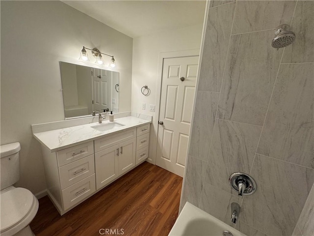 bathroom featuring toilet, tub / shower combination, wood finished floors, and vanity