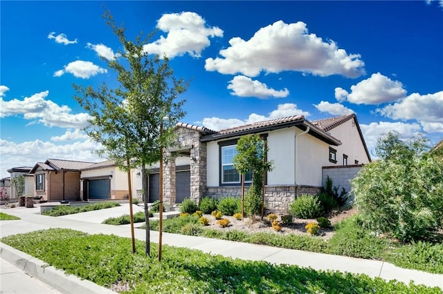 4021 E Perdido Privado, Ontario, CA 91761 - view of front facade with stone siding, a garage, stucco siding, concrete driveway, and a tiled roof