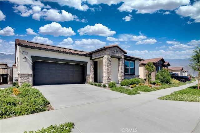 4021 E Perdido Privado, Ontario, CA 91761 - view of front of house featuring an attached garage, driveway, stucco siding, and stone siding