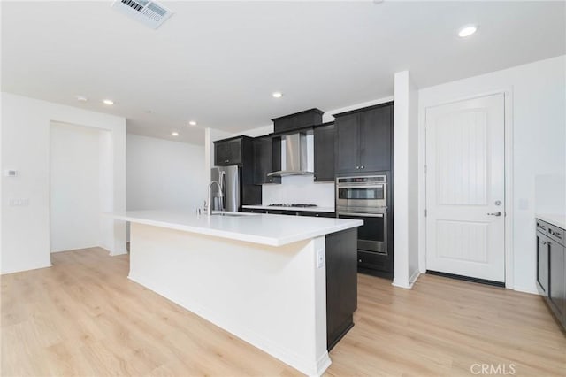 4021 E Perdido Privado, Ontario, CA 91761 - kitchen with visible vents, an island with sink, wall chimney range hood, light countertops, and stainless steel appliances
