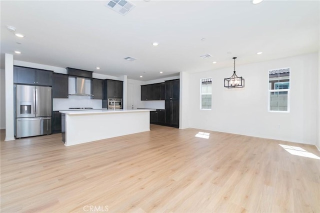 4021 E Perdido Privado, Ontario, CA 91761 - kitchen with light countertops, wall chimney exhaust hood, stainless steel appliances, open floor plan, and visible vents