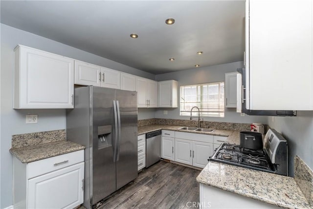 kitchen featuring dark wood-style flooring, appliances with stainless steel finishes, a sink, white cabinets, and recessed lighting