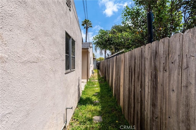 view of property exterior with stucco siding and fence