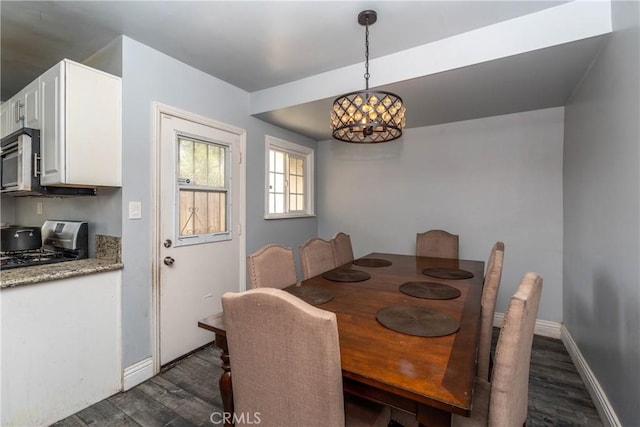 dining space with baseboards, dark wood-style flooring, and a notable chandelier