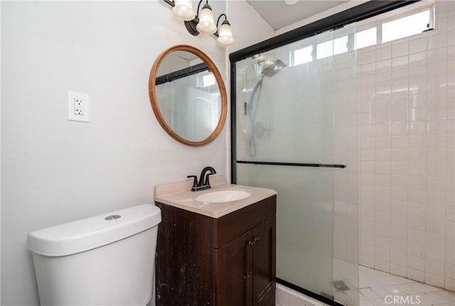 bathroom with vanity, toilet, and tiled shower