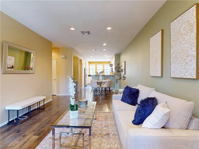 living area with recessed lighting, baseboards, visible vents, and wood finished floors