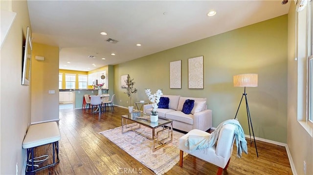 living area with wood-type flooring, recessed lighting, baseboards, and visible vents