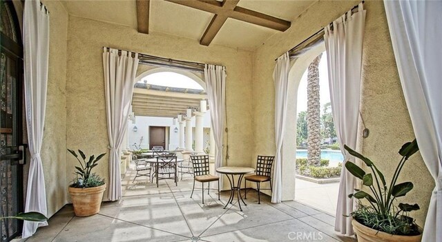doorway to outside with beam ceiling and coffered ceiling