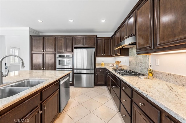 kitchen with appliances with stainless steel finishes, under cabinet range hood, a sink, crown molding, and dark brown cabinets