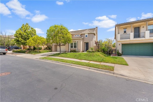 view of front of home with concrete driveway, a front yard, and stucco siding