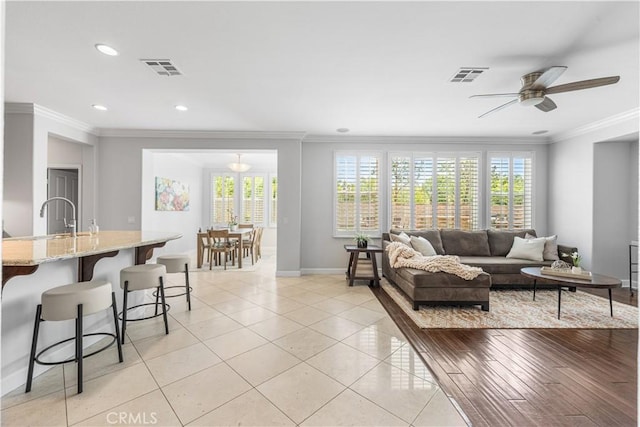 living room with ornamental molding, baseboards, ceiling fan, recessed lighting, and light tile patterned flooring