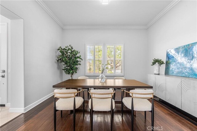 dining area featuring crown molding, wood-type flooring, and baseboards