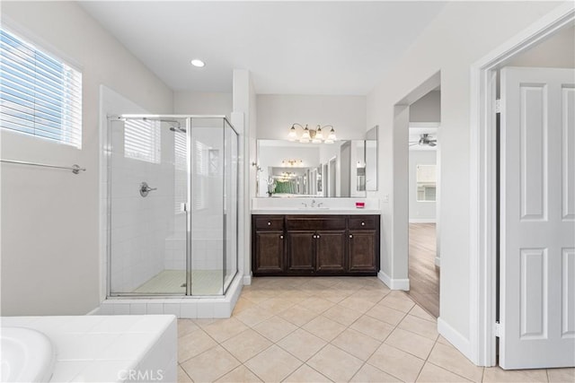 full bath with a stall shower, tile patterned floors, vanity, ceiling fan, and baseboards