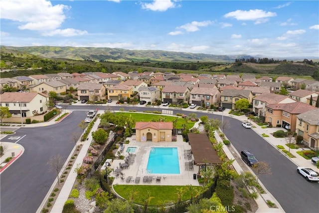 aerial perspective of suburban area featuring a pool area and mountains