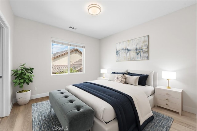 bedroom featuring baseboards and light wood finished floors