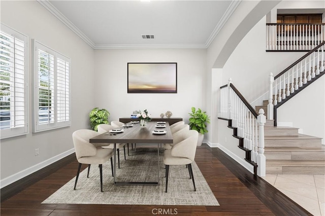 dining room featuring crown molding, stairway, wood finished floors, baseboards, and arched walkways