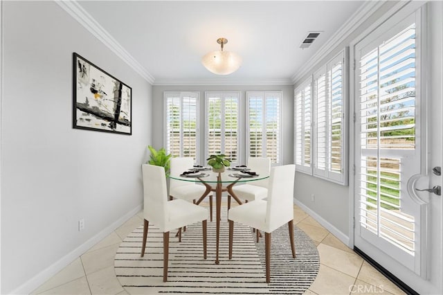 dining area with light tile patterned floors, healthy amount of natural light, crown molding, and baseboards