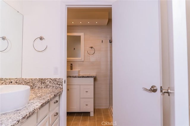 full bath with tiled shower, tile patterned flooring, and vanity