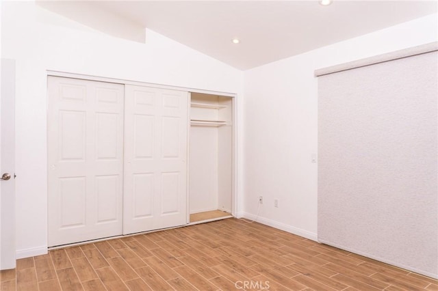 unfurnished bedroom with baseboards, recessed lighting, light wood-style flooring, and lofted ceiling