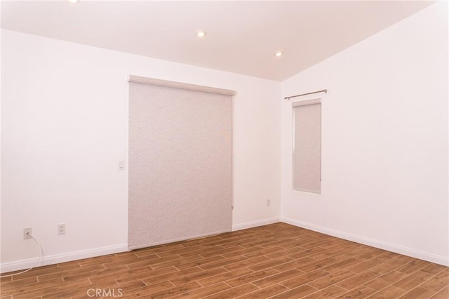 unfurnished room featuring recessed lighting, baseboards, and wood finished floors
