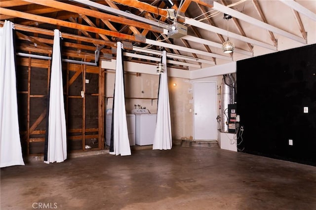 miscellaneous room featuring concrete flooring, washer / dryer, and lofted ceiling