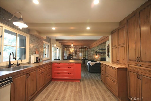 kitchen with white dishwasher, a sink, light wood-style flooring, a peninsula, and open floor plan