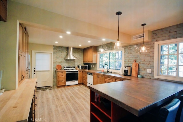 kitchen featuring a sink, wall chimney exhaust hood, white range with gas stovetop, visible vents, and dishwashing machine