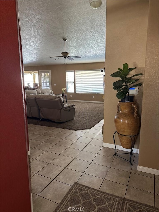 17815 Chestnut St, Hesperia, CA 92345 - living room featuring light tile patterned floors, ceiling fan, a textured ceiling, baseboards, and light colored carpet