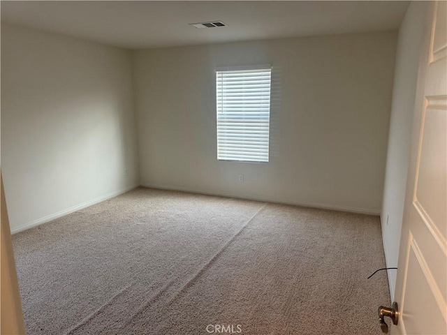 empty room featuring carpet floors, baseboards, and visible vents