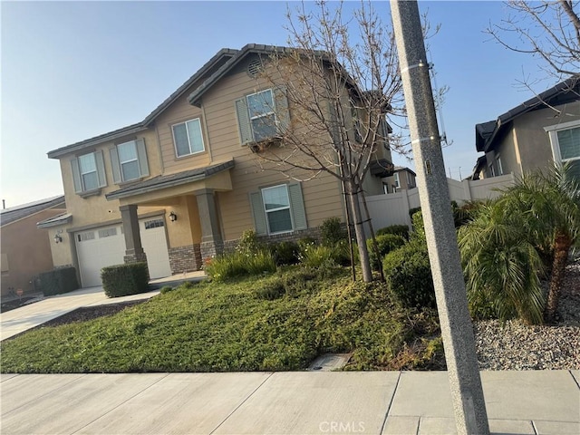 view of front of house featuring fence, driveway, and a garage