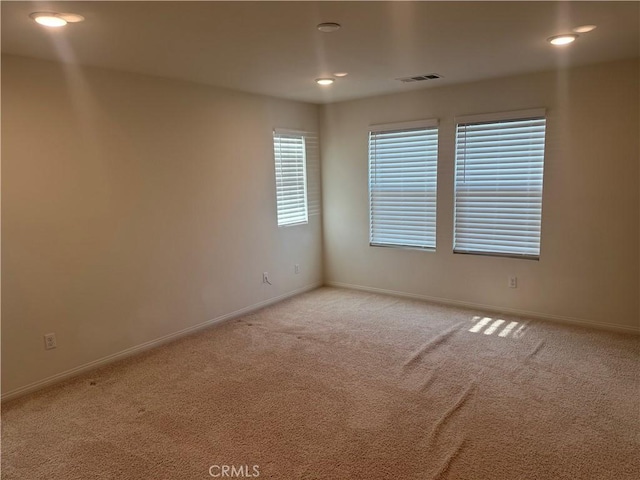 spare room with baseboards, carpet flooring, and visible vents