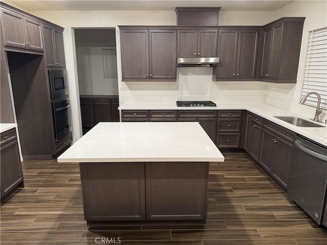 kitchen with a sink, appliances with stainless steel finishes, dark brown cabinetry, and wood tiled floor