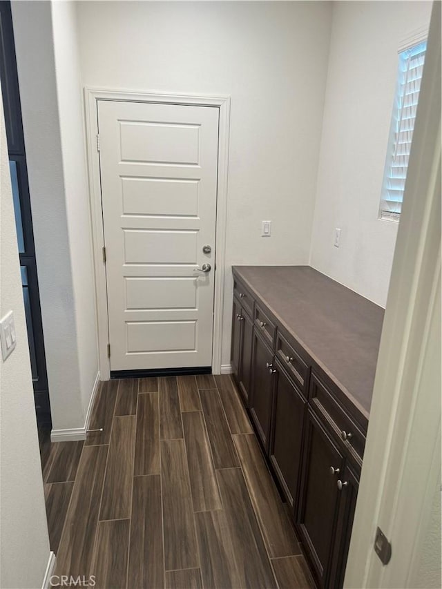entryway with wood tiled floor and baseboards