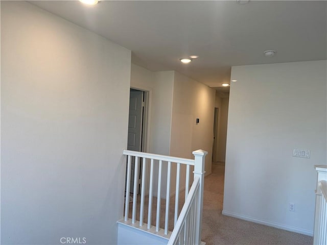 hall featuring baseboards, light colored carpet, recessed lighting, and an upstairs landing