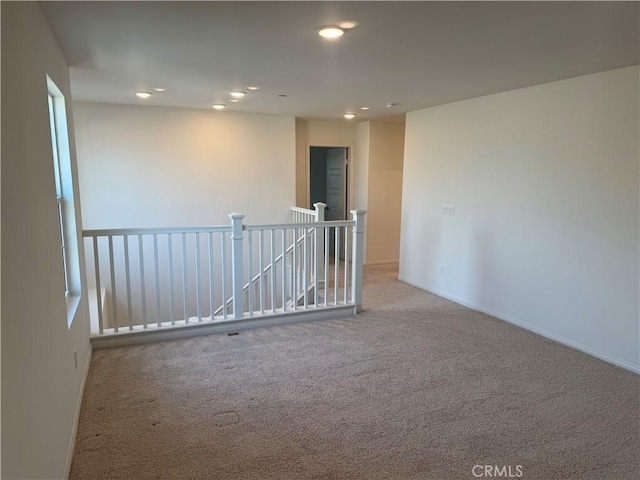 carpeted spare room featuring recessed lighting and baseboards