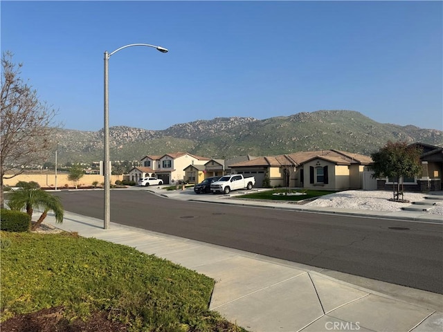 view of street with street lights, a mountain view, and sidewalks