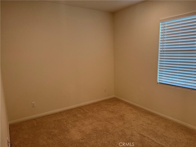 carpeted spare room with baseboards