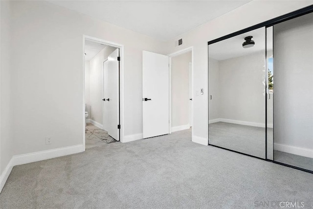 unfurnished bedroom featuring visible vents, carpet, baseboards, and a closet
