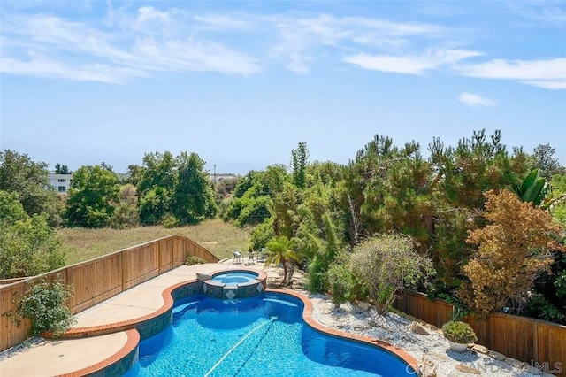 view of swimming pool featuring a pool with connected hot tub and a fenced backyard