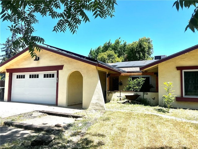 3324 Columbia Ave, Merced, CA 95340 - view of front of property with an attached garage, roof mounted solar panels, stucco siding, and a front yard