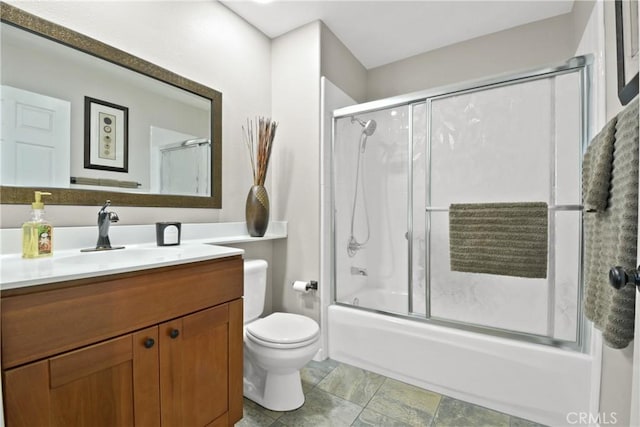 bathroom with toilet, bath / shower combo with glass door, and vanity