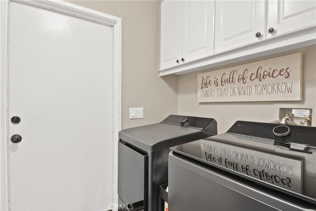 clothes washing area with cabinet space and independent washer and dryer