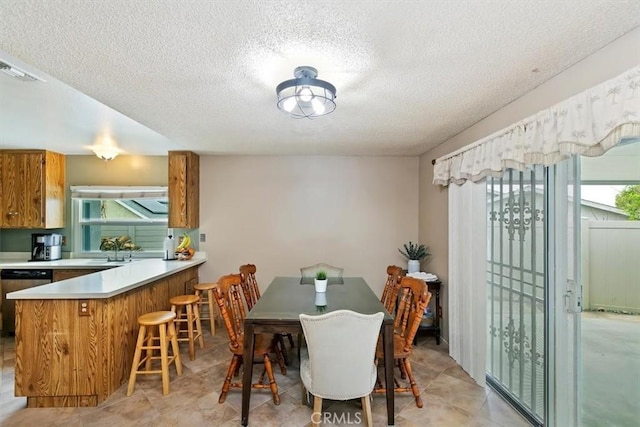 dining space with a textured ceiling, visible vents, and light tile patterned floors