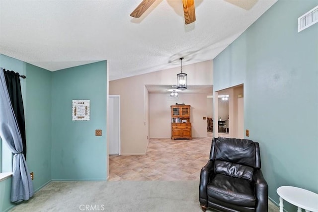 sitting room featuring ceiling fan, a textured ceiling, visible vents, vaulted ceiling, and carpet