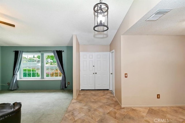 entrance foyer with a textured ceiling, visible vents, and baseboards