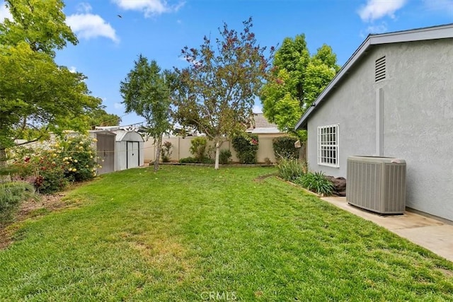 view of yard with a storage shed, central AC, an outbuilding, and a fenced backyard