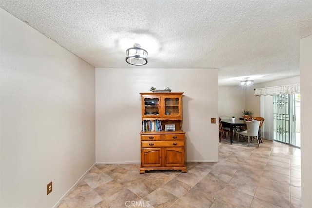 dining room with baseboards and a textured ceiling